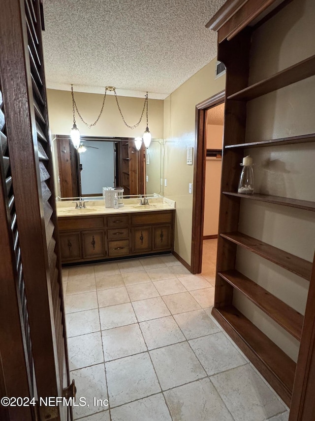 bathroom with vanity, a textured ceiling, ceiling fan, and tile patterned flooring