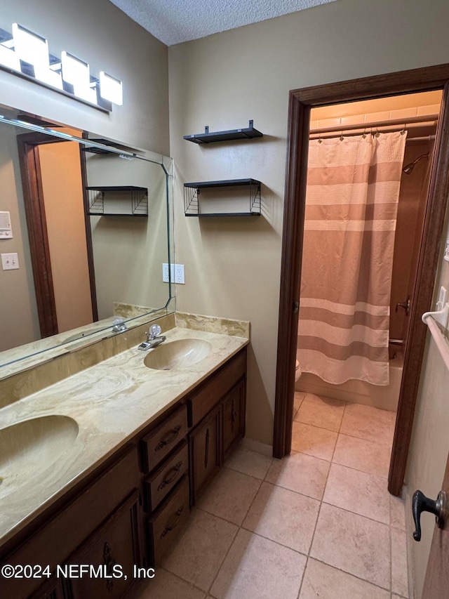 bathroom featuring tile patterned flooring, vanity, and a textured ceiling