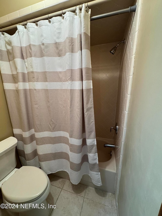 bathroom with tile patterned flooring, shower / tub combo with curtain, and toilet