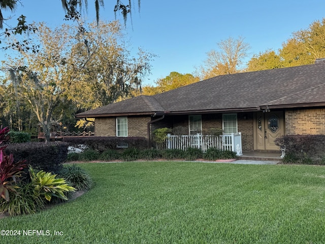 ranch-style house with a porch and a front yard