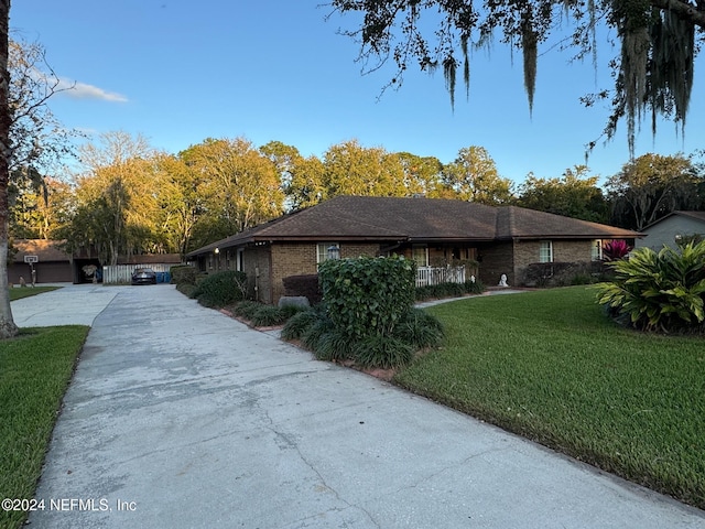 single story home featuring a front lawn