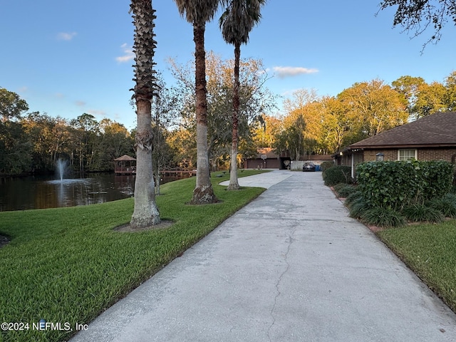 view of home's community with a yard and a water view