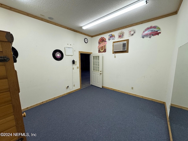 carpeted spare room with an AC wall unit, crown molding, and a textured ceiling