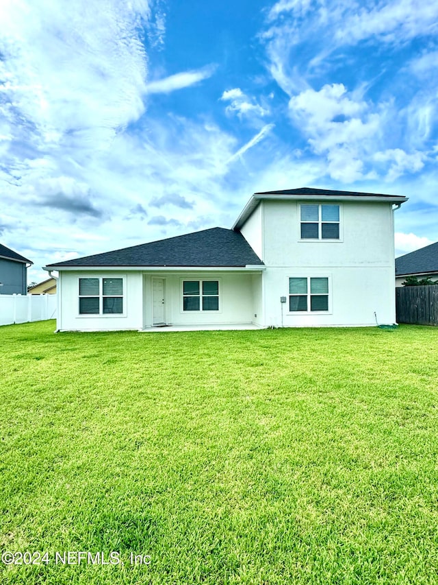 rear view of property with a yard