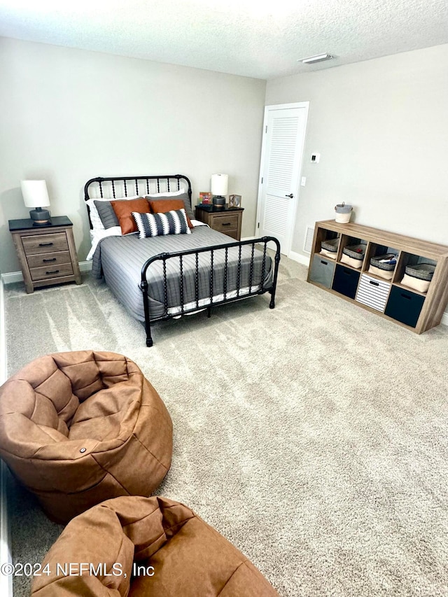 bedroom with carpet and a textured ceiling