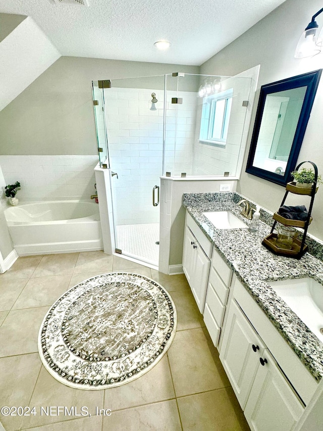 bathroom with tile patterned flooring, vanity, a textured ceiling, and plus walk in shower