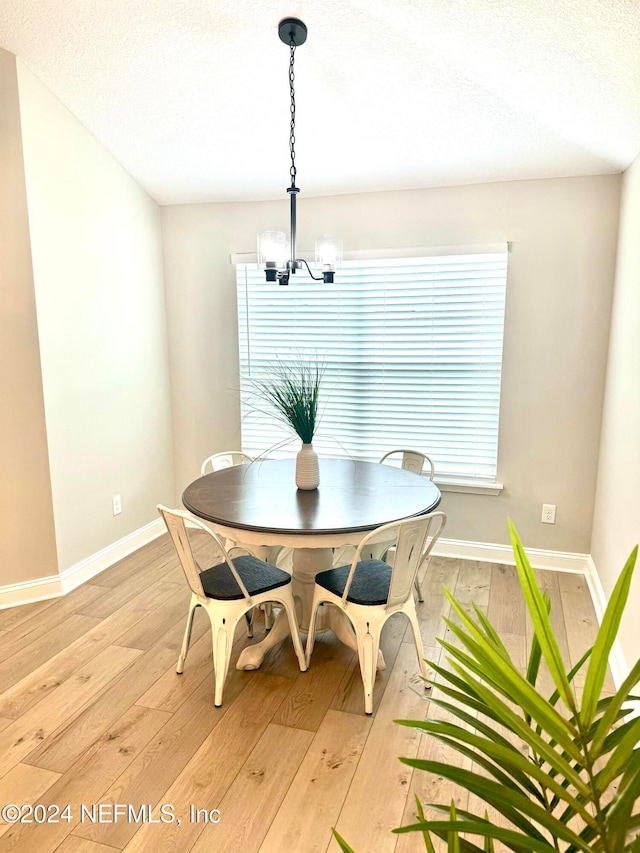 dining space featuring a wealth of natural light, a chandelier, and light wood-type flooring