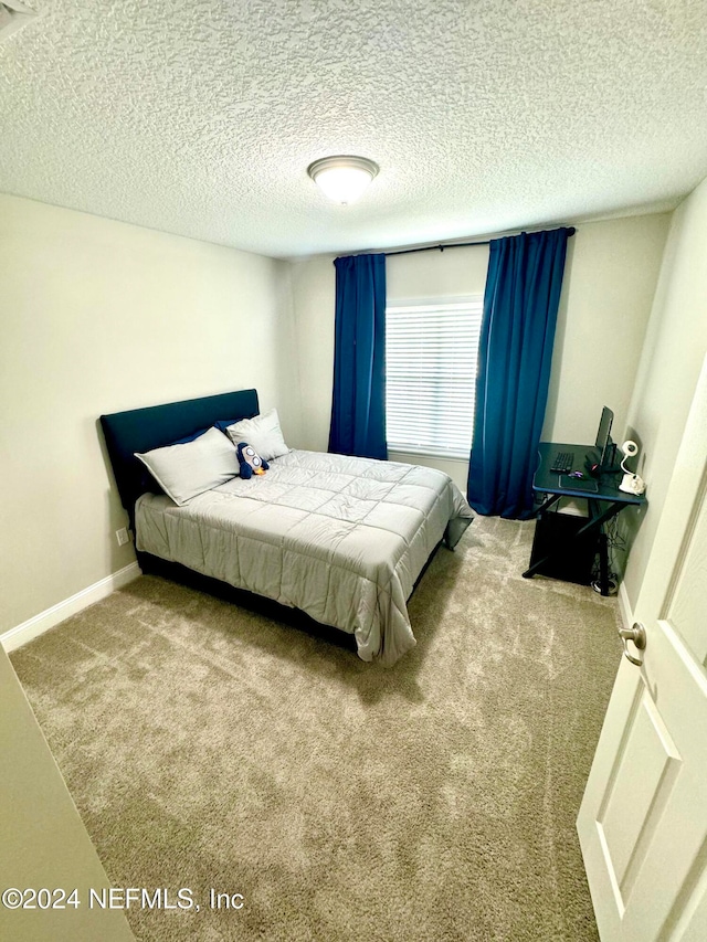 carpeted bedroom with a textured ceiling