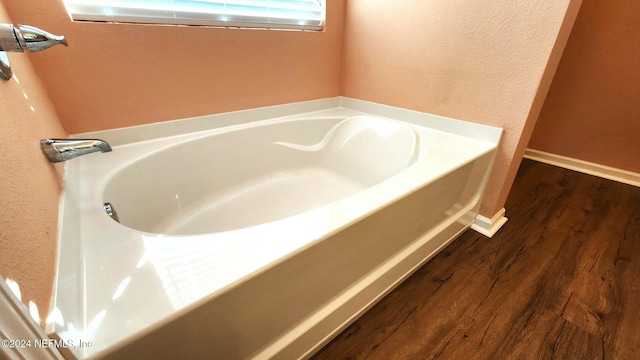 bathroom featuring hardwood / wood-style floors and a washtub