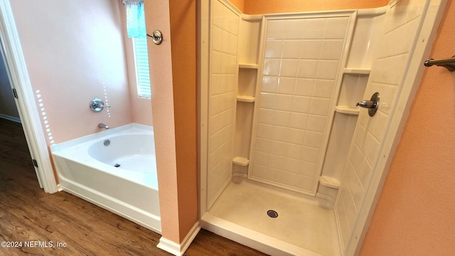 bathroom featuring plus walk in shower and hardwood / wood-style flooring