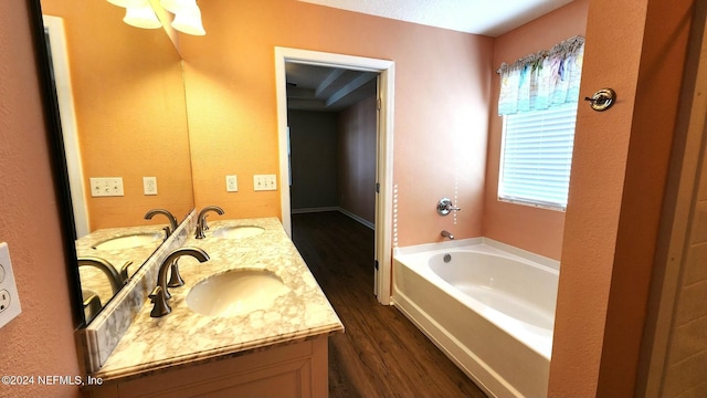 bathroom featuring vanity, hardwood / wood-style flooring, and a bathtub