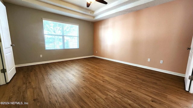 empty room with ceiling fan and dark wood-type flooring