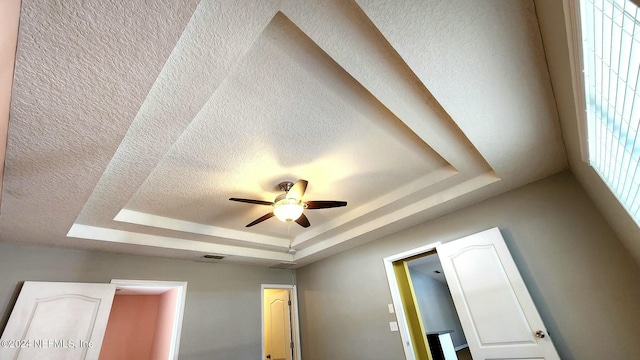 room details featuring a raised ceiling and ceiling fan