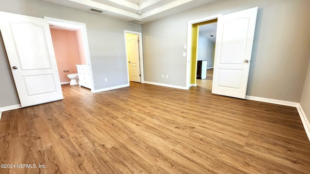 unfurnished bedroom featuring light wood-type flooring and connected bathroom