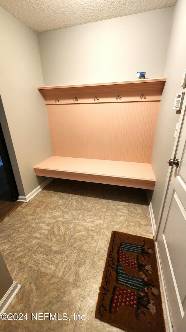 mudroom featuring a textured ceiling