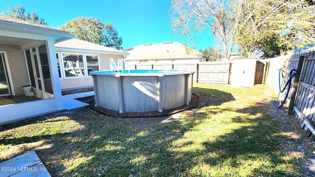 view of yard featuring a fenced in pool and a sunroom