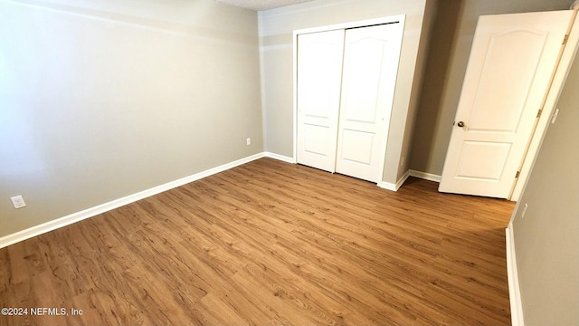 unfurnished bedroom featuring hardwood / wood-style floors and a closet