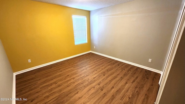 unfurnished room featuring wood-type flooring and a textured ceiling