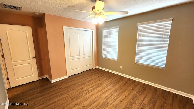 unfurnished bedroom with hardwood / wood-style floors, ceiling fan, a textured ceiling, and a closet