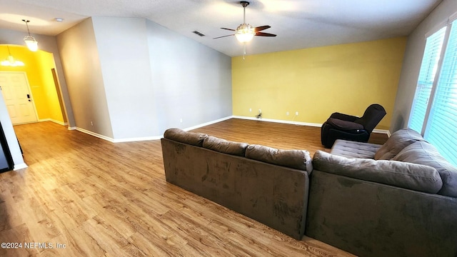 living room featuring ceiling fan, light hardwood / wood-style floors, and lofted ceiling