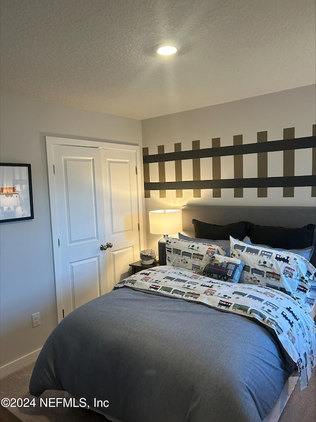 carpeted bedroom with a textured ceiling