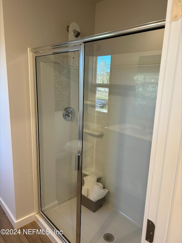 bathroom featuring hardwood / wood-style flooring and an enclosed shower