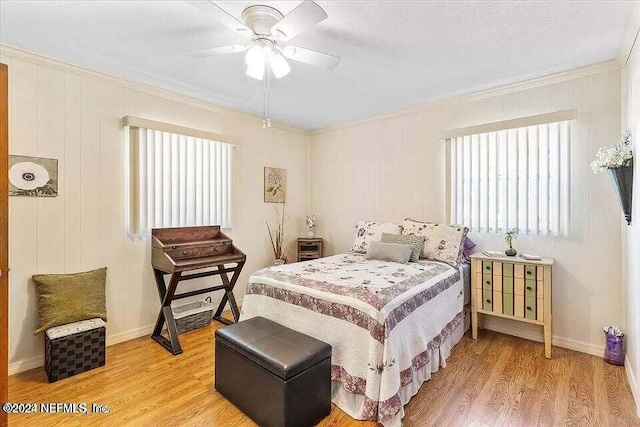 bedroom featuring ceiling fan, ornamental molding, and hardwood / wood-style flooring