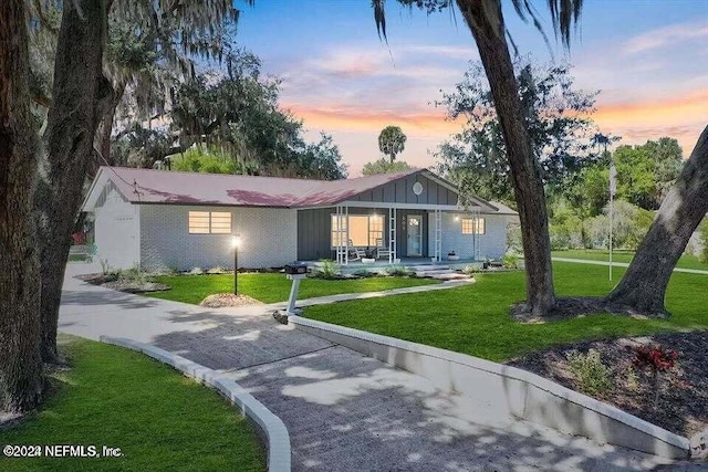 ranch-style home with a yard and a porch