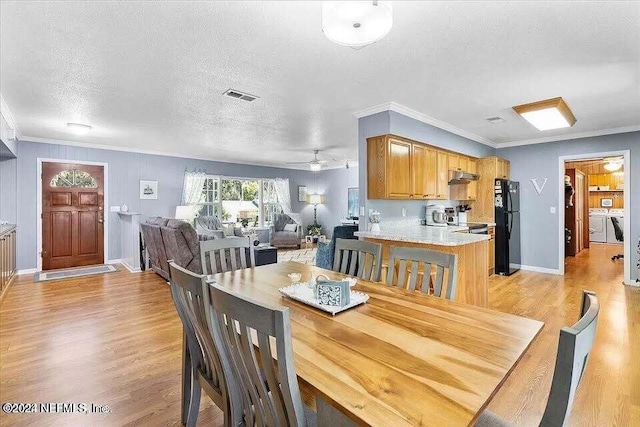 dining area with ceiling fan, light hardwood / wood-style flooring, crown molding, a textured ceiling, and washer and dryer