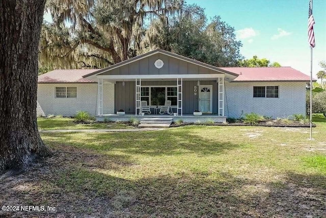 ranch-style house featuring a front lawn and covered porch