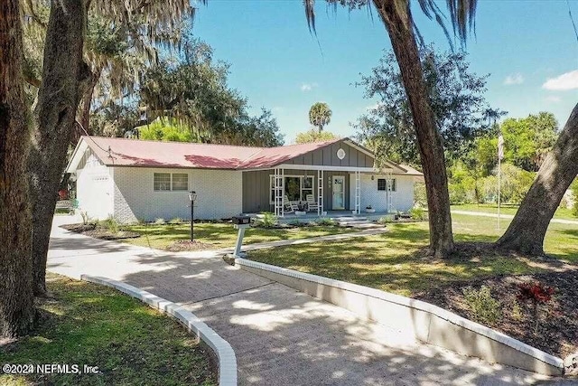 ranch-style home with covered porch and a front yard