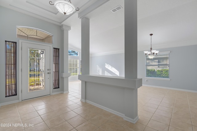 entryway with light tile patterned floors, vaulted ceiling, an inviting chandelier, and a wealth of natural light