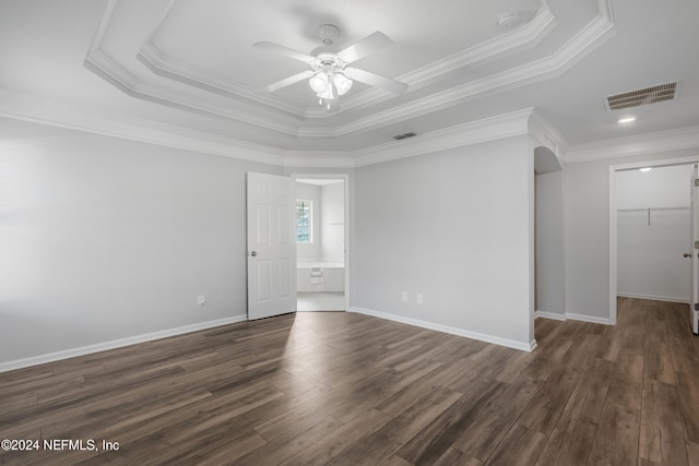 unfurnished room featuring dark hardwood / wood-style floors, a tray ceiling, ornamental molding, and ceiling fan