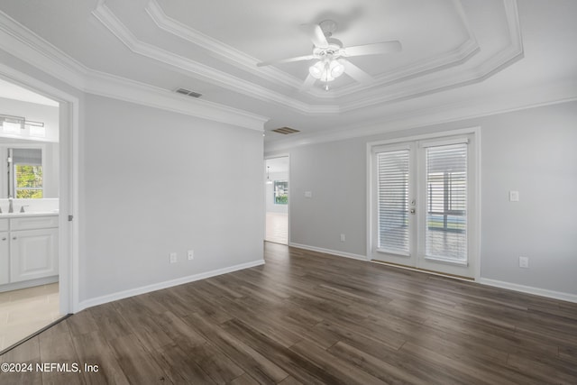 empty room featuring dark hardwood / wood-style floors, a tray ceiling, and french doors