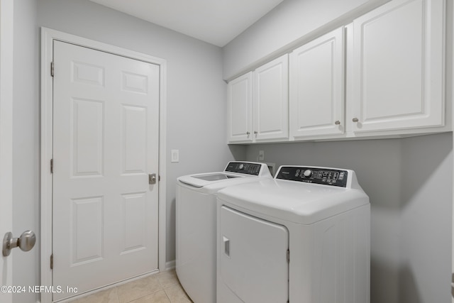 washroom with washer and dryer, light tile patterned flooring, and cabinets