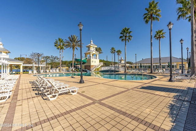 view of pool featuring a patio and a water slide