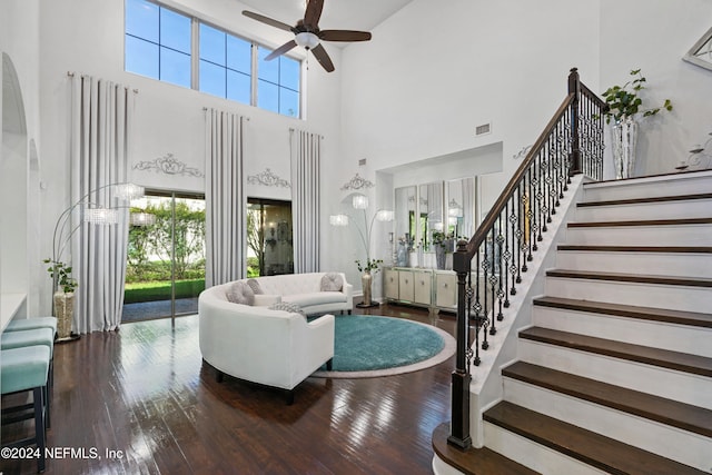 living room with ceiling fan, a high ceiling, and hardwood / wood-style flooring