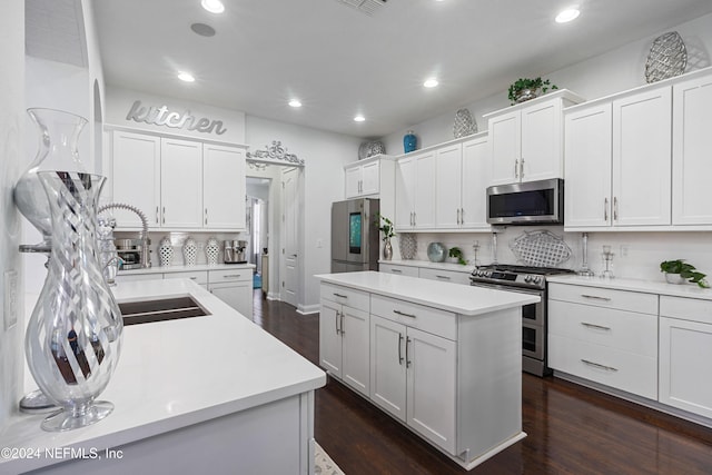 kitchen featuring white cabinetry, a center island, stainless steel appliances, tasteful backsplash, and dark hardwood / wood-style flooring