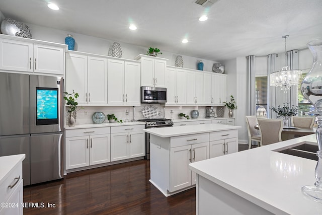 kitchen with stainless steel appliances, tasteful backsplash, dark hardwood / wood-style floors, decorative light fixtures, and white cabinets