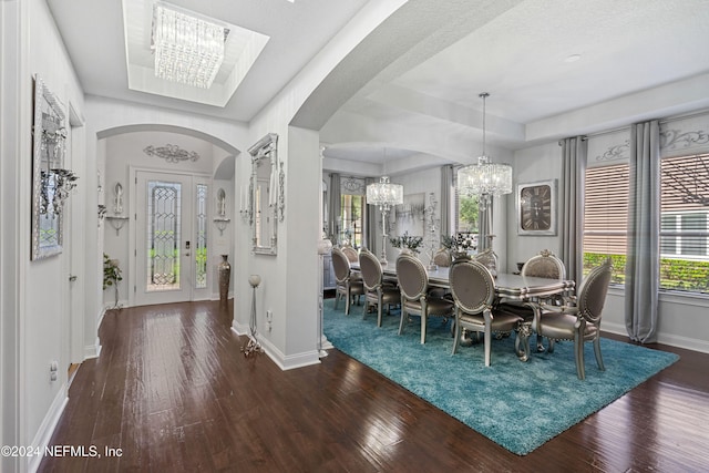 dining room featuring a notable chandelier, dark hardwood / wood-style floors, and a tray ceiling