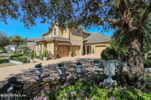 view of front of property featuring stucco siding, driveway, and an attached garage