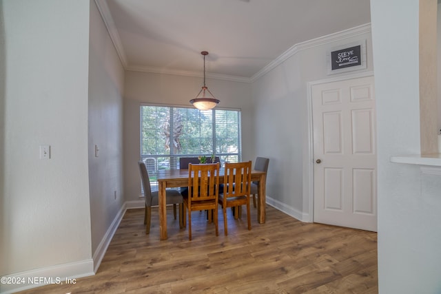 dining space with wood-type flooring and ornamental molding