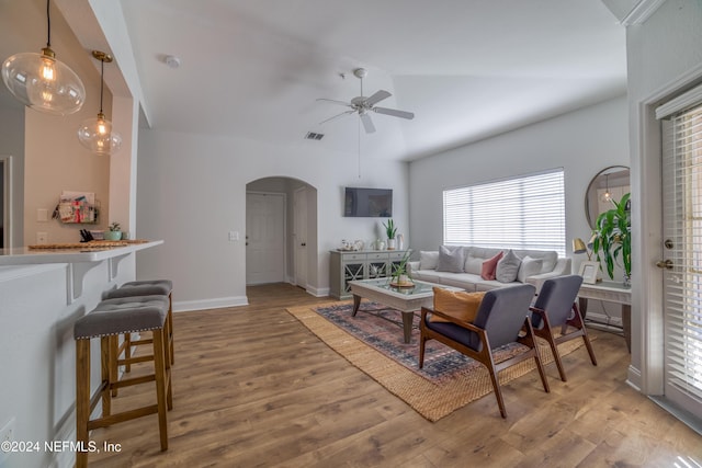 living room featuring hardwood / wood-style flooring, ceiling fan, and vaulted ceiling