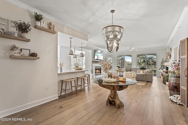 415 N Ocean Grande Dr Unit 101, Ponte Vedra Beach, FL 32082 - dining room featuring crown molding, a fireplace, wood-type flooring, a textured ceiling, and baseboards