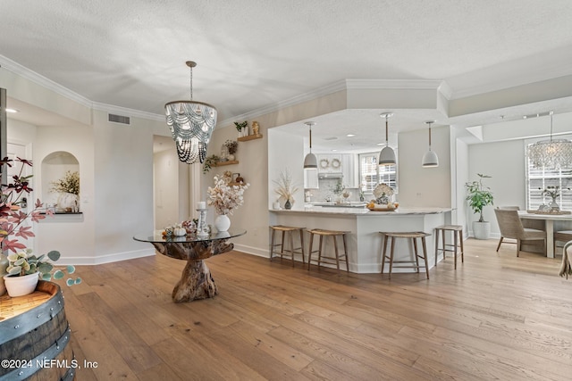 415 N Ocean Grande Dr Unit 101, Ponte Vedra Beach, FL 32082 - dining area featuring light wood finished floors, baseboards, a chandelier, crown molding, and a textured ceiling