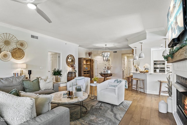 415 N Ocean Grande Dr Unit 101, Ponte Vedra Beach, FL 32082 - living room with crown molding, a lit fireplace, hardwood / wood-style floors, and ceiling fan