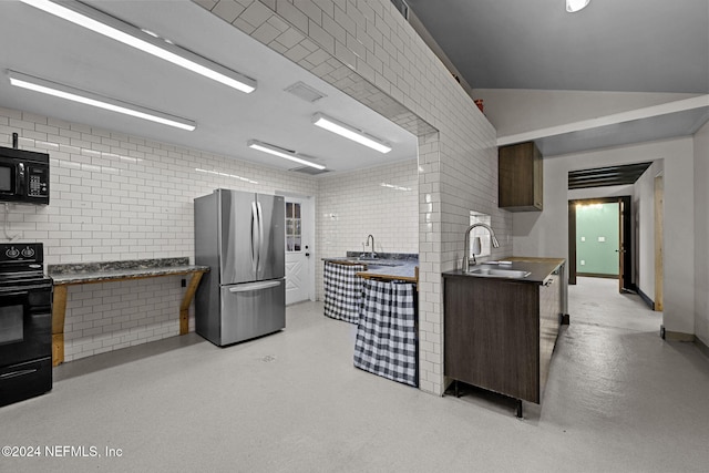 kitchen featuring black appliances, dark brown cabinets, sink, and brick wall