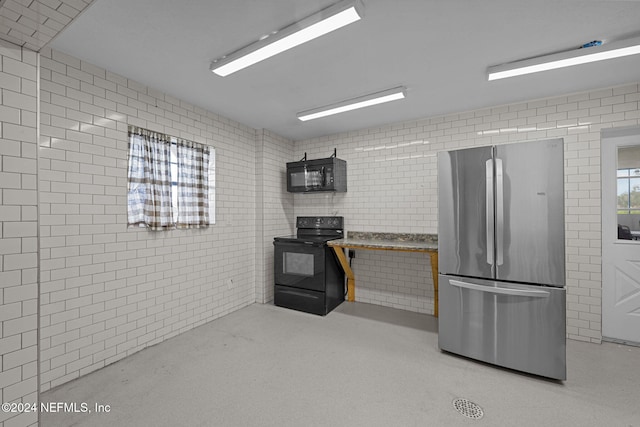 kitchen with black appliances and brick wall