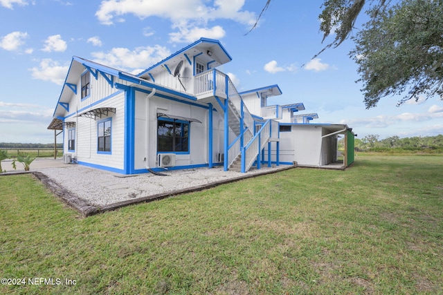 back of property with a balcony and a yard