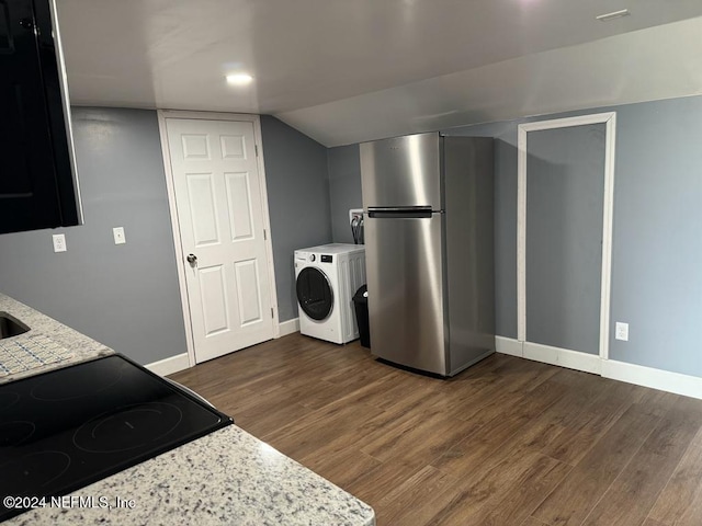 kitchen featuring black range, dark hardwood / wood-style floors, stainless steel refrigerator, light stone counters, and washer / clothes dryer